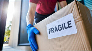 Delivery driver with box marked fragile