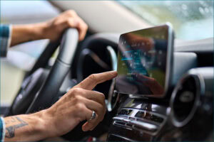 Man in car using touch screen device